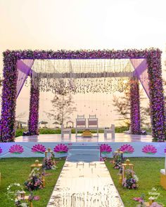 an outdoor wedding setup with purple flowers and greenery