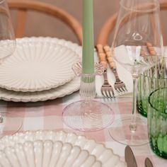 the table is set with plates, glasses and utensils