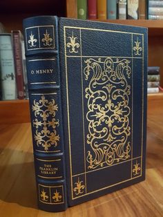 an old book sitting on top of a wooden table in front of bookshelves