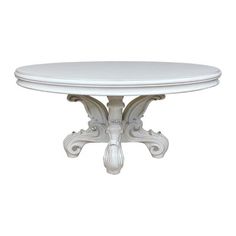 a white table with an ornate design on the top and base, against a white background