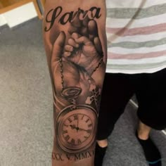 a person with a tattoo on their arm holding a pocket watch and the word papa