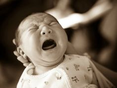 a baby crying with its mouth wide open