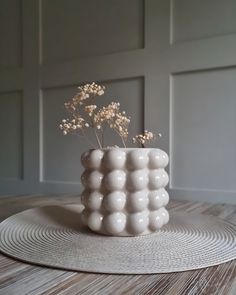 a white vase sitting on top of a wooden table