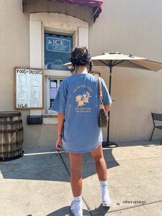 a woman standing in front of an ice cream shop with her back to the camera