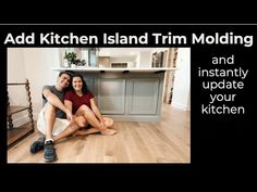 a man and woman sitting on the floor in front of a kitchen island trim molding