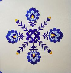 a blue and white embroidered design on a white cloth with yellow accents is featured in this image