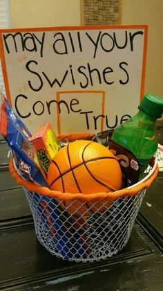 a basket filled with oranges and candy next to a sign that says may all your swishes come true