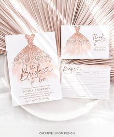 the wedding stationery is set on top of a white plate with pink and gold foil