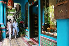 two women are walking down the street in front of shops