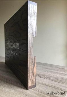 a wooden box sitting on top of a hard wood floor next to a vase with flowers in it