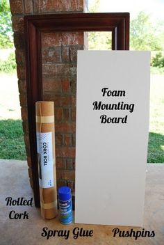 a sign and some glue sitting on the ground next to a brick wall with an advertisement for foam mounting board