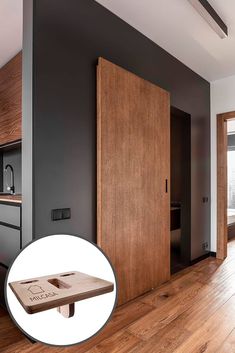 an open wooden door in a room with hardwood floors and black walls on the wall