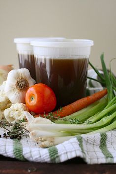 there are some vegetables on the table and two cups of coffee next to each other