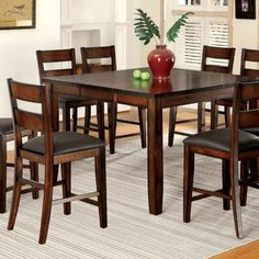 a dining room table with chairs and a vase