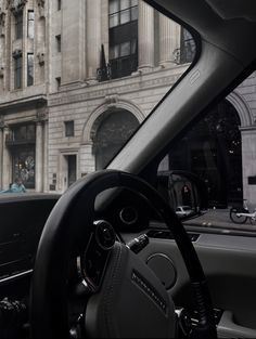 the interior of a car is shown in front of an old building with columns and arches