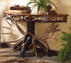 a table with deer heads on it in front of a plant and potted plants