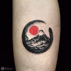 a tattoo on the leg of a person with a mountain and red sun in the background