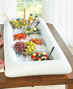 an inflatable table with food on it and plates, cups, glasses and utensils