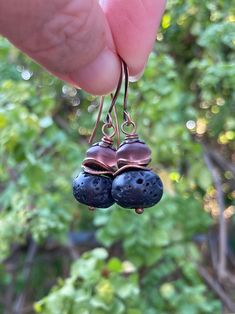 Lava Rock & Purple Sea Glass Drops Aromatherapy Jewelry Black Natural Stone Earrings Dusky purple beads made from recycled glass sit above some copper chips and a black lava rock bead. These are porous and hold essential oils well -- rub a drop of your favorite oil on each one and enjoy the scent all day. The soft Aubergine glass glows in the sunlight.  Ear wires are sloped, contoured antique copper plated brass. These measure about 1.5" long. Will arrive in a kraft style gift box. Nature-inspired Natural Stone Earrings For Gift, Purple Drop Earrings With Natural Stones, Vintage Teardrop Natural Stone Earrings, Black Natural Stones Drop Earrings, Black Natural Stone Dangle Earrings, Aromatherapy Jewelry, Natural Stone Earrings, Lava Rock, Style Gift