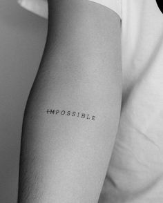 a man's arm with the word impossible written on it in cursive font