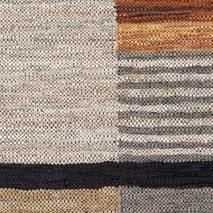 a multicolored rug with black, brown, beige and white squares on it