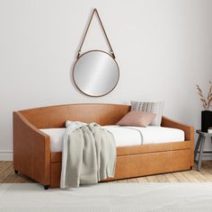 a day bed with a mirror on the wall above it