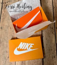 an orange and white nike box sitting on top of a wooden floor