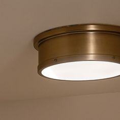 a round light fixture in a room with beige walls and white carpeting on the floor