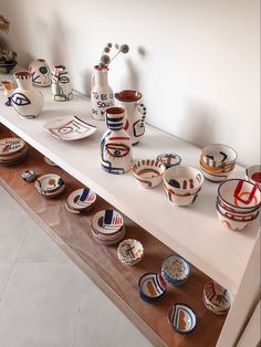 several bowls and plates on a shelf in a room