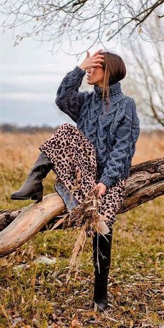 a woman sitting on top of a tree branch