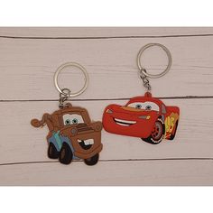 two key chains with cars on them sitting next to each other