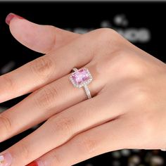 a woman's hand with a pink diamond ring on it