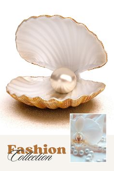 a white pearl in an oyster shell with pearls on the bottom and gold trimmings