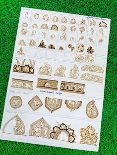 some gold and white stickers sitting on top of a green grass covered field with lots of different designs