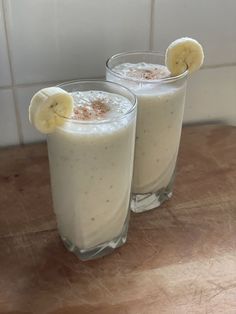 two glasses filled with milk and banana slices