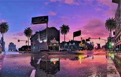 a city street at dusk with palm trees on the side and traffic lights in the background