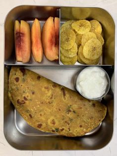 a metal tray filled with food and fruit