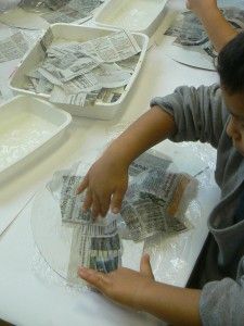 two boys are making money at a table