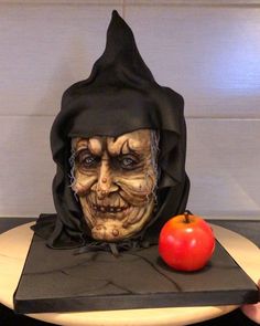 a person holding a plate with a fake head on it and an apple next to it