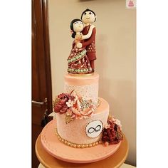 a three tiered cake with an image of a man and woman on top