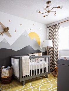 a baby's room decorated in black, white and yellow with an airplane painted on the wall