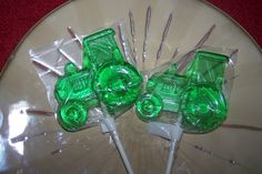 two green lollipops sitting on top of a white plate