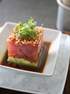 a plate with some food on it and sauce in the bowl next to it,