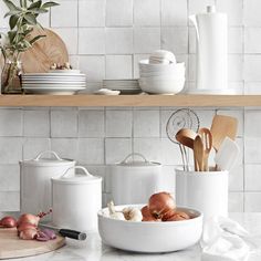 white kitchenware and utensils are arranged on the counter