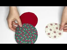 two people are making small coasters out of fabric and paper plates, one is red and the other is green