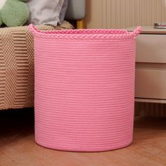 a pink basket sitting on top of a wooden floor