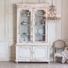 an old white china cabinet with glass doors