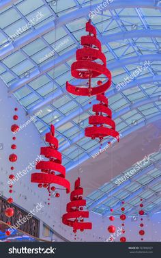 red lanterns hanging from the ceiling in an indoor shopping mall with glass roof and skylights