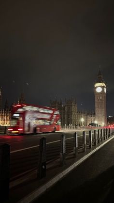 the big ben clock tower towering over the city of london at night with traffic passing by