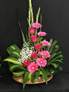 a basket filled with pink flowers and greenery